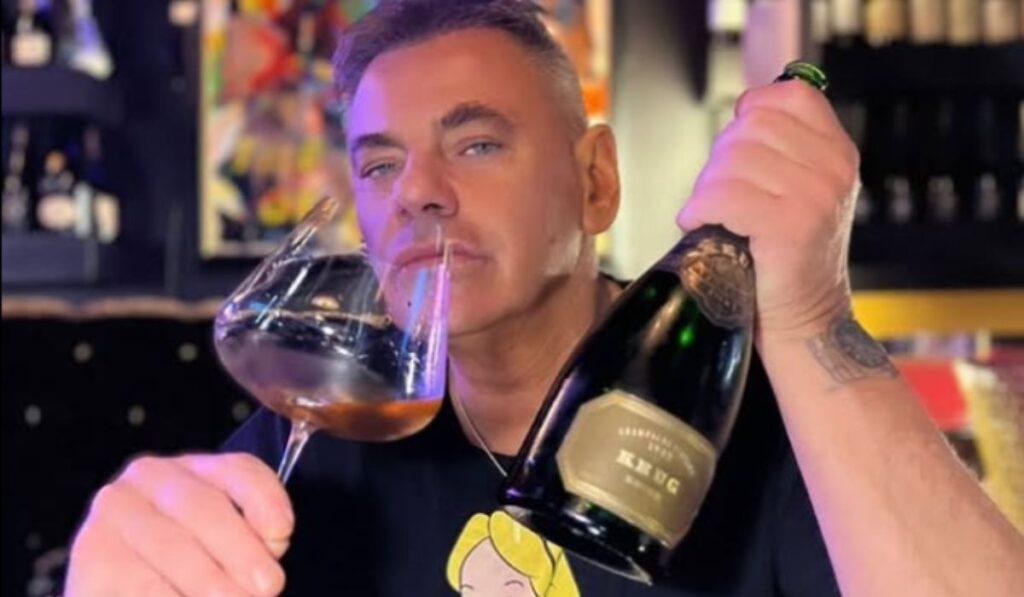 Davide Lacerenza in primo piano con una bottiglia e un calice in mano